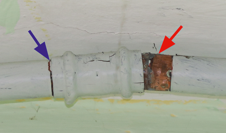 Bild 6 / Eine Pressverbindung innerhalb einer weiß angestrichenen  Kupferrohrleitung wurde durch eine Frosteinwirkung leicht (blauer Pfeil)  bzw. fast komplett (roter Pfeil) getrennt.
